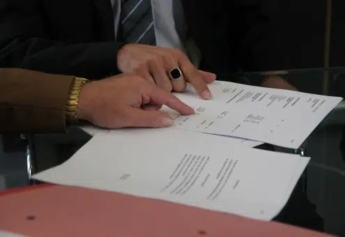 Gros plan sur des mains pointant un document, pour illustrer la réforme en droits des contrats